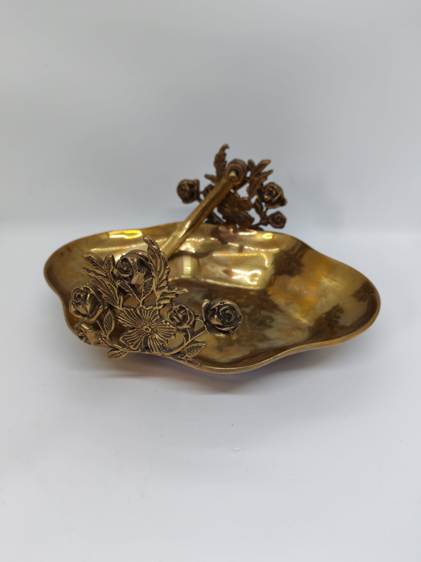 Small brass tray with floral decorations and a handle